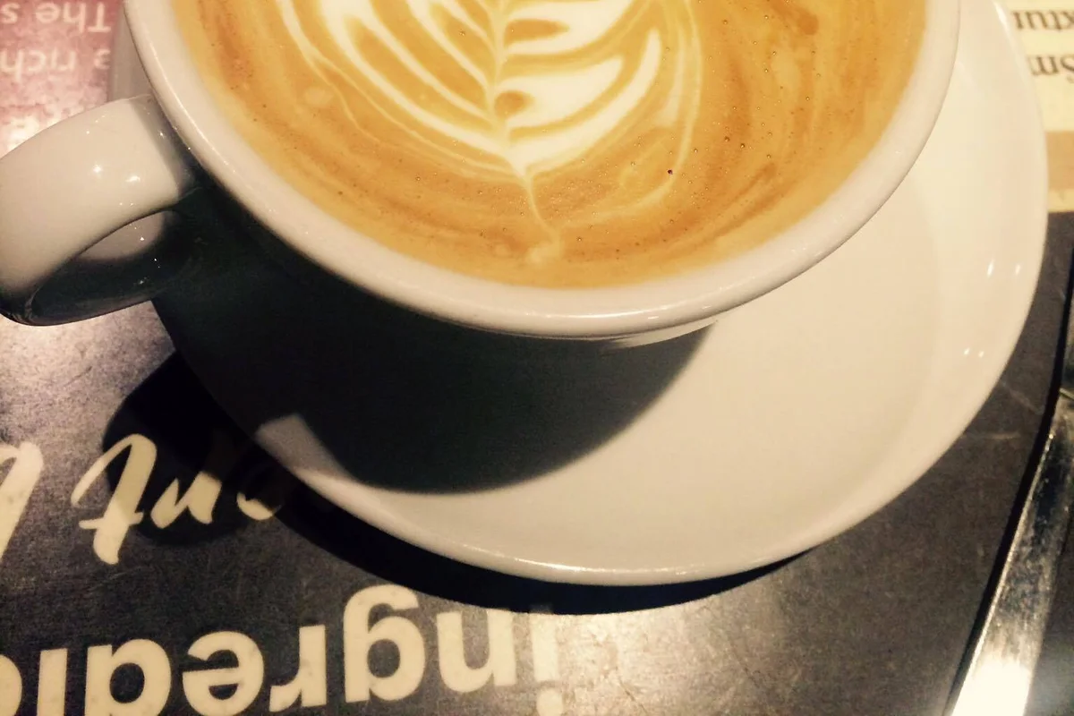 Flat white coffee with feather-shaped latte art